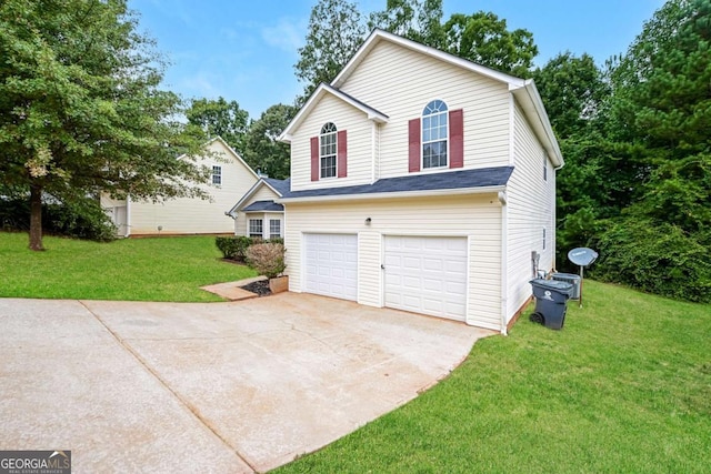view of front of property featuring an attached garage, driveway, and a front lawn