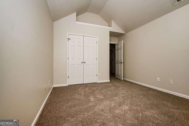 unfurnished bedroom featuring carpet floors, a closet, visible vents, baseboards, and vaulted ceiling