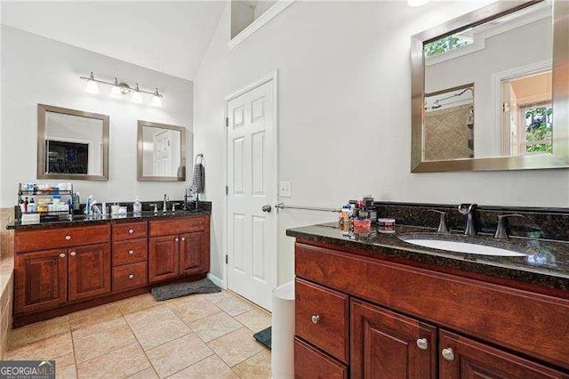 bathroom featuring tile patterned floors, vaulted ceiling, tiled shower, and vanity