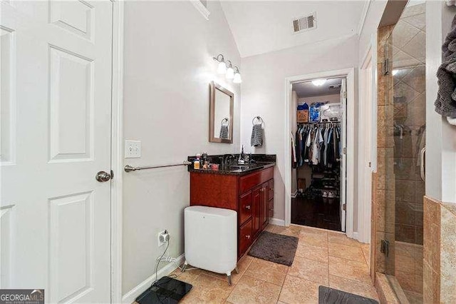 full bathroom with a walk in closet, visible vents, a shower stall, vanity, and tile patterned floors