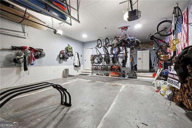 garage featuring a garage door opener and a wainscoted wall
