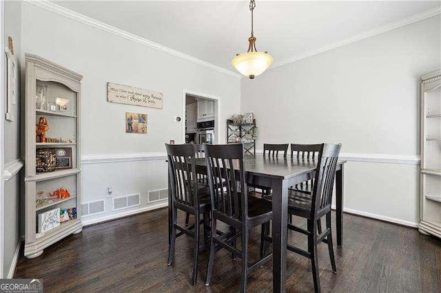 dining space with crown molding, dark wood-style flooring, baseboards, and visible vents