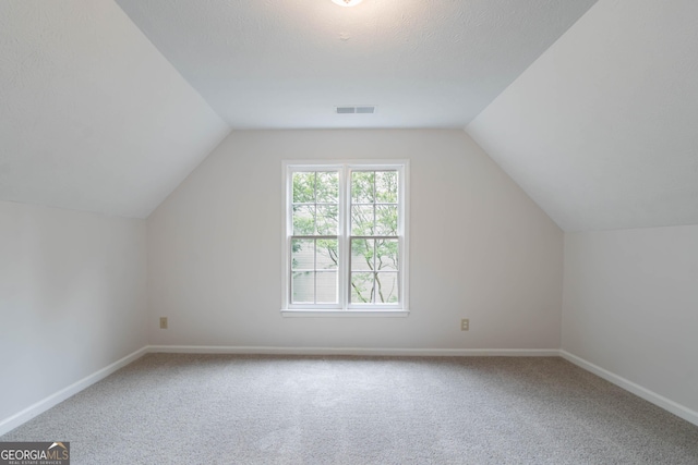 bonus room featuring carpet flooring, visible vents, and lofted ceiling