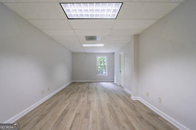 spare room with baseboards, visible vents, a paneled ceiling, and light wood finished floors