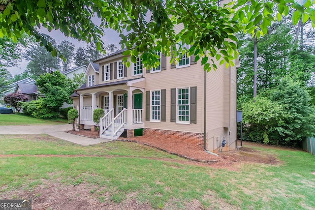 view of front of house featuring covered porch and a front lawn
