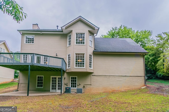 back of house with a patio area, a wooden deck, a yard, and a chimney