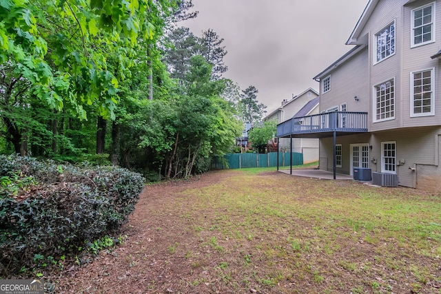 view of yard with central AC, a patio area, fence, and a wooden deck
