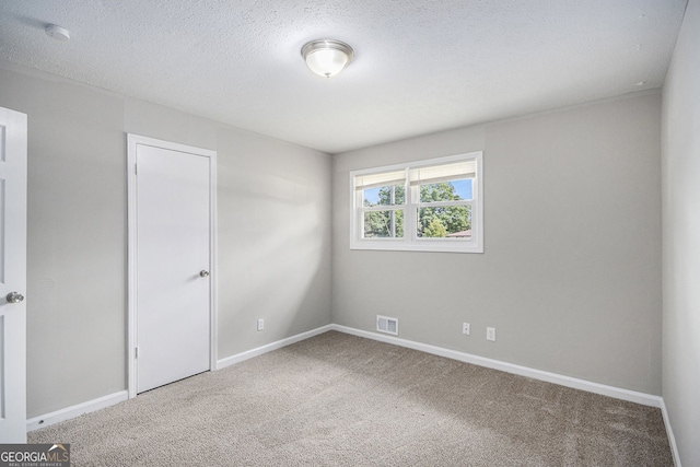 unfurnished bedroom with visible vents, carpet flooring, baseboards, and a textured ceiling