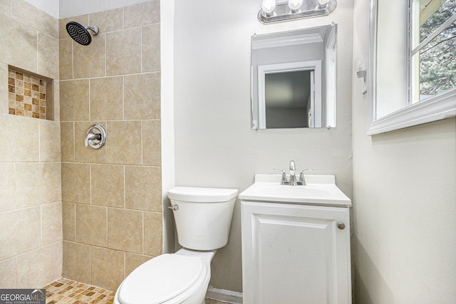 full bathroom with vanity, a tile shower, and toilet