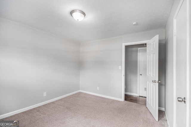 unfurnished bedroom with baseboards, a textured ceiling, and carpet