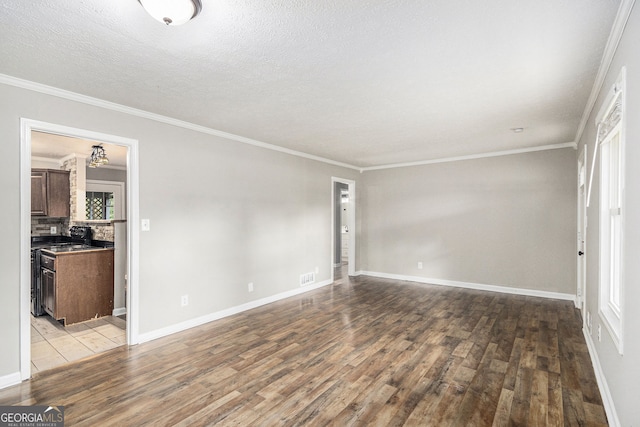 unfurnished living room with baseboards, ornamental molding, a textured ceiling, and wood finished floors