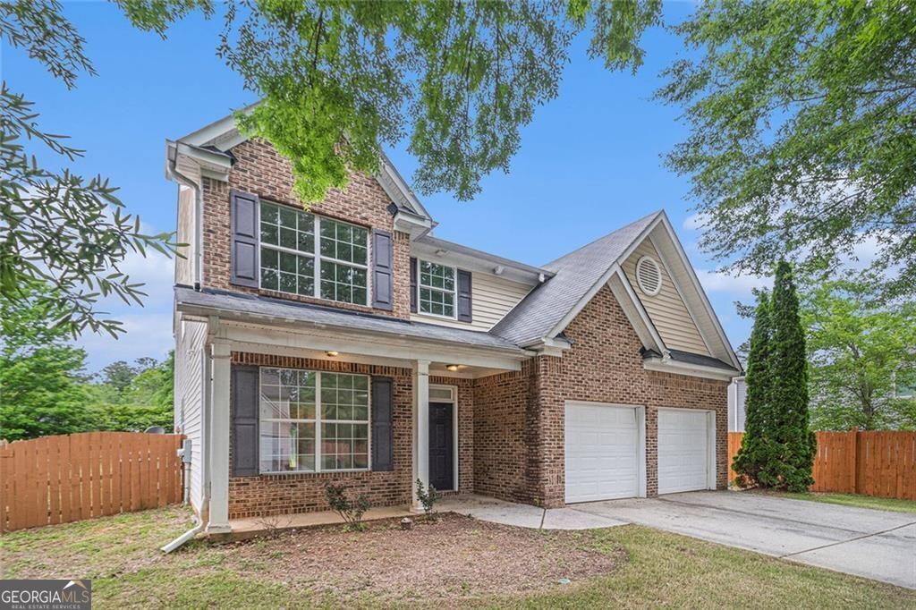 7454 Silver Arrow Trl SE, Austell, GA 30168 - traditional home with driveway, brick siding, fence, and a garage