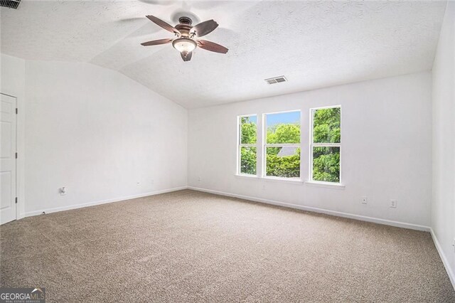 7454 Silver Arrow Trl SE, Austell, GA 30168 - spare room featuring carpet floors, a ceiling fan, lofted ceiling, and a textured ceiling