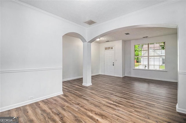 7454 Silver Arrow Trl SE, Austell, GA 30168 - empty room featuring wood finished floors, a textured ceiling, arched walkways, and crown molding