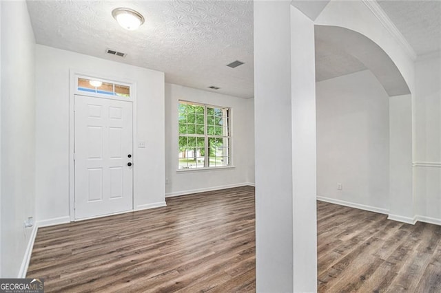 7454 Silver Arrow Trl SE, Austell, GA 30168 - entryway with a textured ceiling, wood finished floors, arched walkways, and crown molding