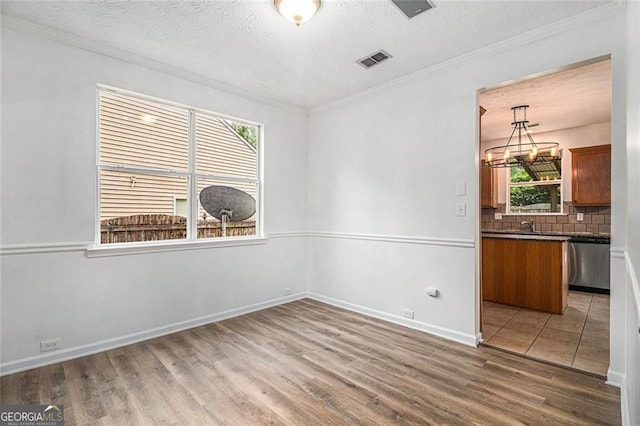 7454 Silver Arrow Trl SE, Austell, GA 30168 - unfurnished dining area with wood finished floors, ornamental molding, a textured ceiling, and a chandelier