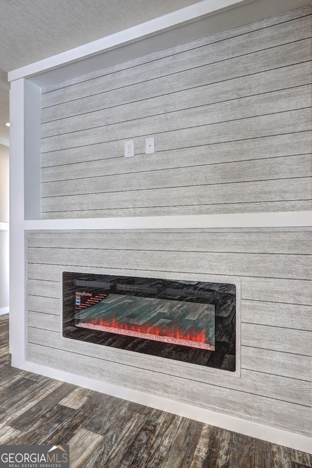 interior details featuring a glass covered fireplace and wood finished floors