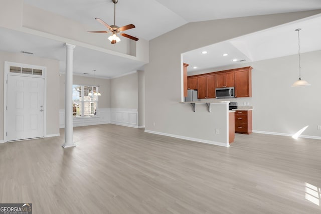 unfurnished living room with a ceiling fan, decorative columns, and light wood-type flooring
