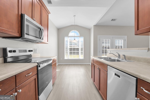 kitchen featuring visible vents, appliances with stainless steel finishes, a sink, light countertops, and light wood-style floors