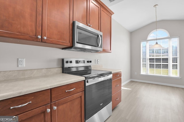 kitchen featuring light countertops, stainless steel appliances, baseboards, and light wood-type flooring