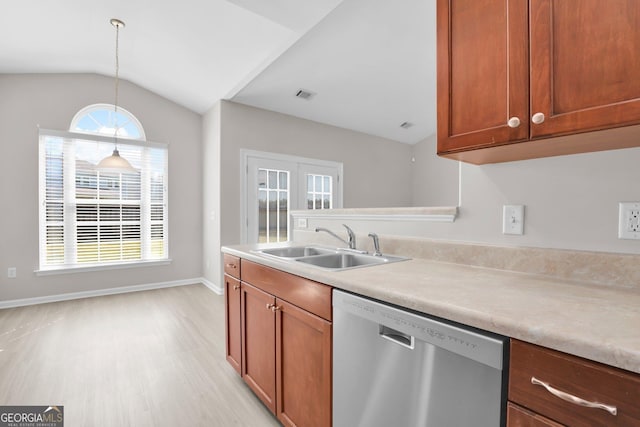 kitchen with brown cabinets, a sink, light wood-style floors, light countertops, and stainless steel dishwasher