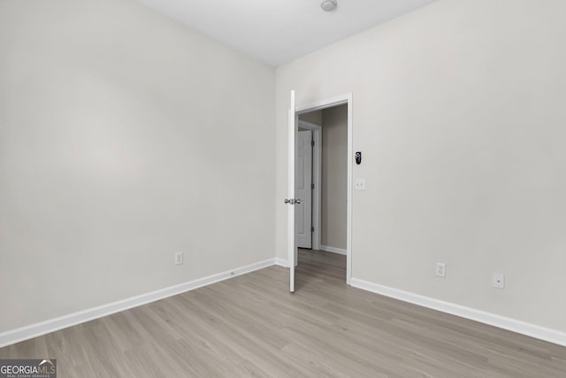 empty room featuring baseboards and light wood-style flooring