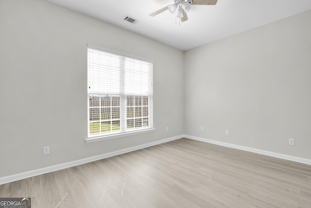 unfurnished room featuring plenty of natural light, a ceiling fan, baseboards, and wood finished floors
