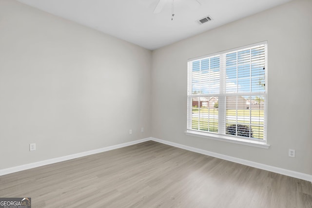 unfurnished room with visible vents, baseboards, ceiling fan, and wood finished floors