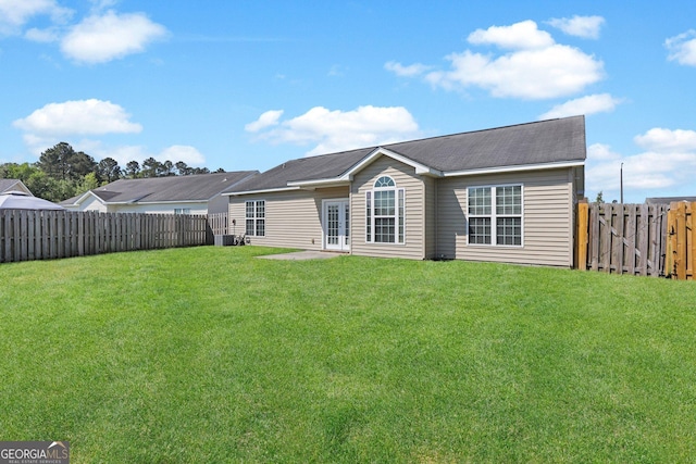 back of house with a lawn, a fenced backyard, and central AC unit