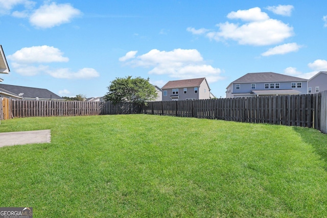 view of yard featuring a fenced backyard and a residential view