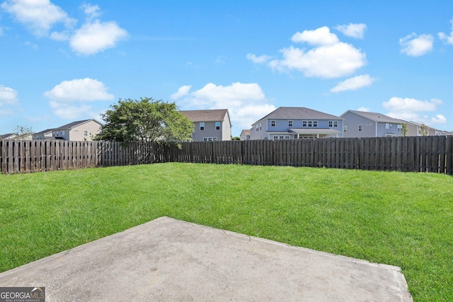 view of yard featuring a patio, a fenced backyard, and a residential view
