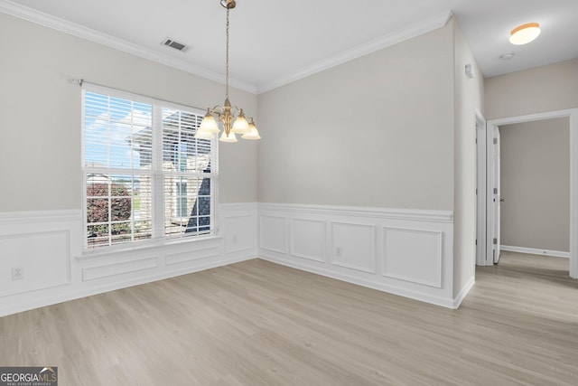 unfurnished dining area with a chandelier, visible vents, wainscoting, and light wood finished floors