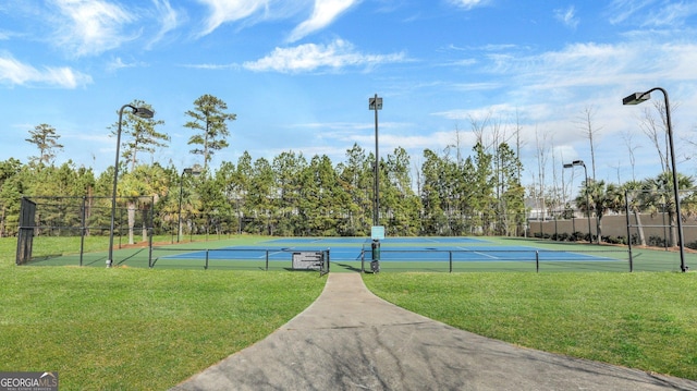 view of sport court featuring a lawn and fence