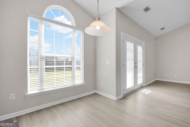 unfurnished dining area with visible vents, vaulted ceiling, and a healthy amount of sunlight