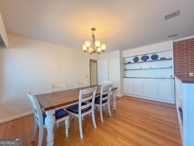 dining room with light wood-style floors, baseboards, visible vents, and a notable chandelier