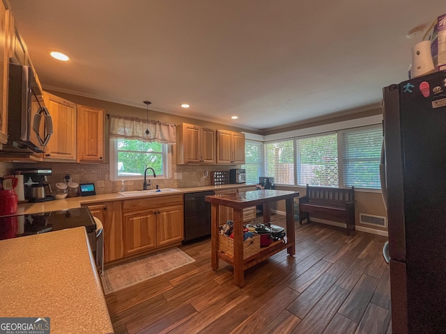 kitchen with appliances with stainless steel finishes, a sink, light countertops, backsplash, and dark wood-style floors