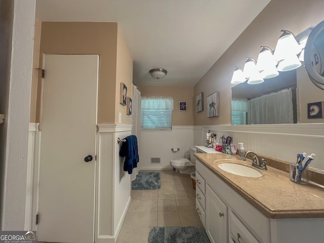 bathroom featuring wainscoting, tile patterned flooring, vanity, toilet, and a shower with shower curtain