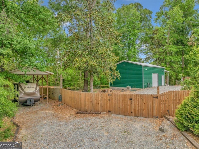 view of property exterior featuring a garage, fence, and an outbuilding