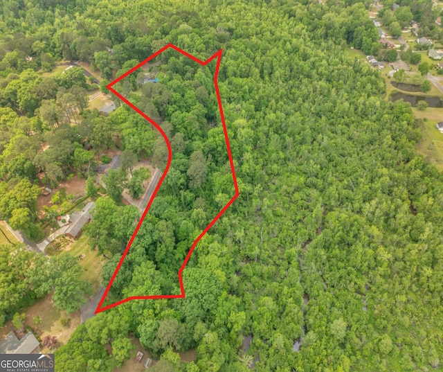 drone / aerial view with a wooded view