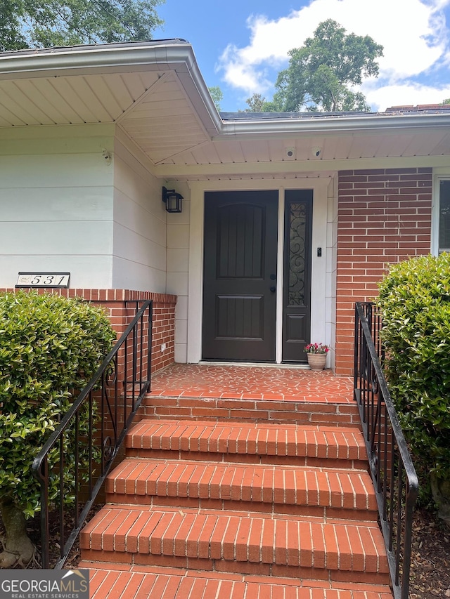 view of exterior entry with brick siding