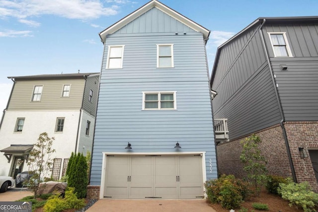 3272 Stillwood Dr, Atlanta, GA 30354 - rear view of property featuring board and batten siding, driveway, and a garage