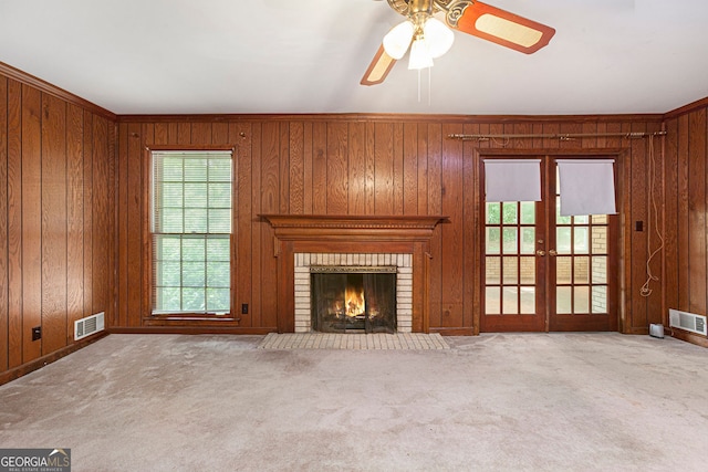 unfurnished living room with a healthy amount of sunlight, carpet floors, and visible vents