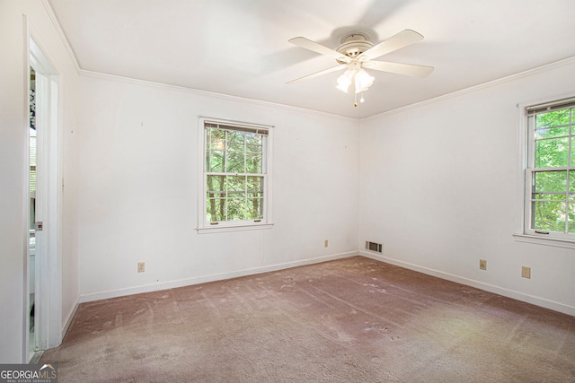 empty room with visible vents, ornamental molding, baseboards, and carpet flooring
