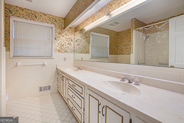 bathroom featuring wallpapered walls, visible vents, a sink, and tile patterned flooring