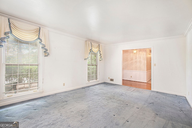carpeted empty room with crown molding and baseboards