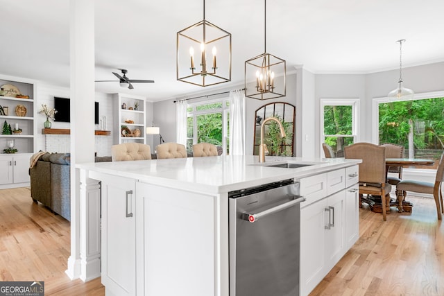 kitchen featuring open floor plan, light wood-type flooring, white cabinets, a sink, and dishwasher
