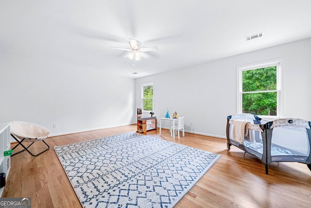 bedroom with visible vents, light wood-style floors, ceiling fan, and baseboards