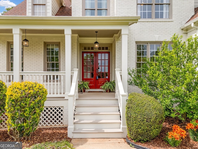 doorway to property with brick siding and a porch