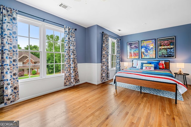 bedroom with multiple windows and wood finished floors