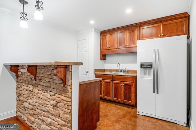 kitchen featuring ornamental molding, light countertops, brown cabinets, a sink, and white fridge with ice dispenser